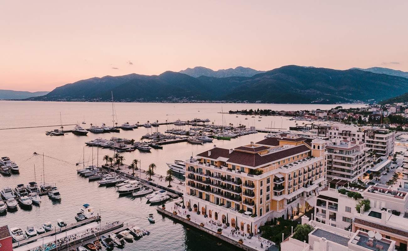 Regent Porto Montenegro vor der Kulisse von Yachthafen und Bergen